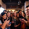 Oameni zâmbitori, interacțiune, smartphone-uri, comunitate unită.